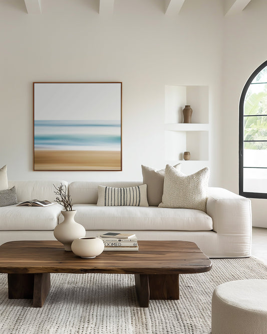 Large coastal canvas print displayed above a white linen sofa in a bright living room — CoastalArtMarket